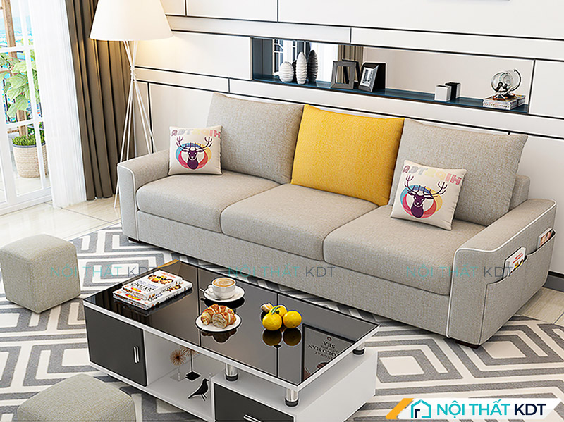 Tham khảo cách bố trí sofa văng 3 chỗ đối diện với bàn trà hình chữ nhật, kết hợp với các ghế đôn nhỏ nhằm tạo nên bố cục hài hoà, cân đối trong phòng khách
