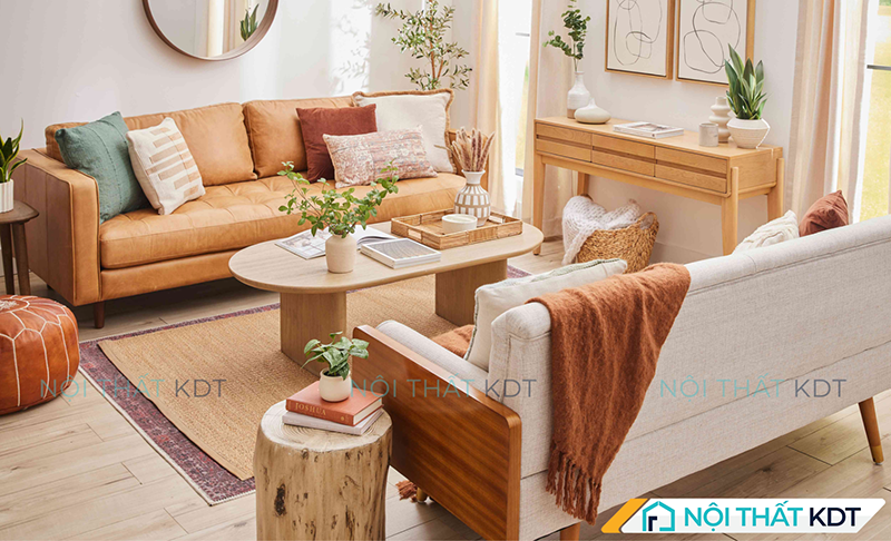 Sofa da màu camel và sofa vải màu kem kê đối diện tạo góc trò chuyện ấm cúng trong không gian sống hiện đại